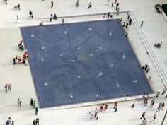 an aerial view of a square with people walking around and on the ground in front of it