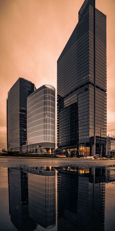 some very tall buildings in the middle of a body of water with reflections on it