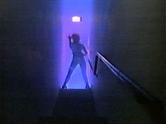 a woman is standing on the stairs in front of a light that is shining down