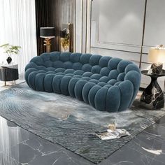 a blue couch sitting on top of a marble floor