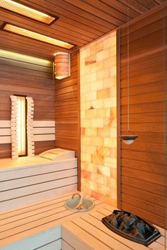 a sauna with wooden walls and lighting in the corner, along with white benches