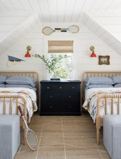 there are two beds in the attic with blue and white bedding