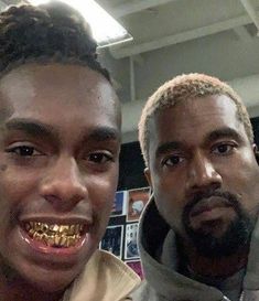 two men with gold teeth are smiling for the camera