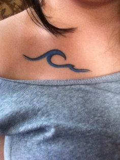 a woman's chest with a wave tattoo on it