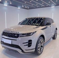 a silver range rover parked in a white room