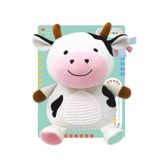 a small stuffed cow sitting on top of a green and white boarder with brown ears