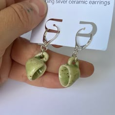 a pair of earrings with green fruit charms