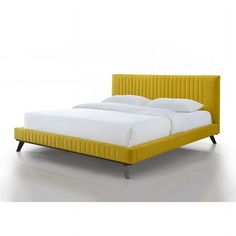 a bed with yellow upholstered headboard and white sheets on the bottom side