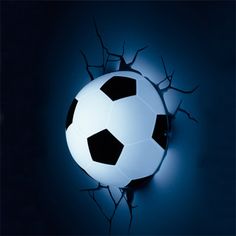 a soccer ball is in the middle of a dark room with light coming through it