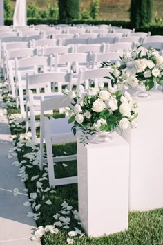 white chairs with flowers and greenery lining the aisle