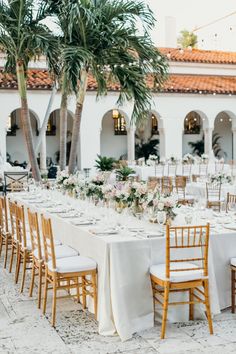 the tables are set up for an outdoor wedding reception with white linens and gold chairs