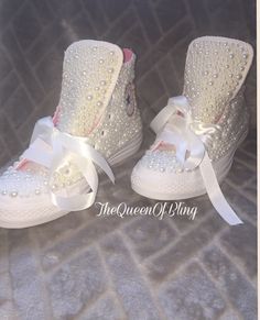 a pair of white shoes with pearls on them