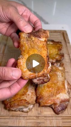 someone is holding up some food on a cutting board with their thumb in the middle