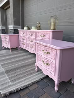 two pink dressers sitting next to each other on top of a rug in front of a building