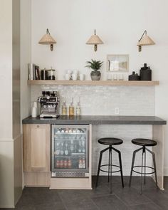 two bar stools sit in front of a counter with an ice cream machine on it