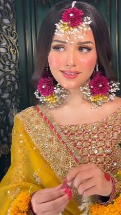 a woman in a yellow and red outfit with flowers on her head is smiling at the camera