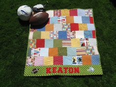 a patchwork quilt on the ground next to a football and soccer ball that says keaton