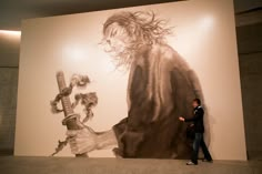 a man standing in front of a large painting