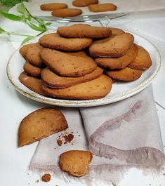 a plate full of cookies on a table next to some napkins and green plants