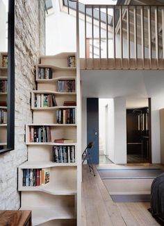 a bookshelf filled with lots of books next to a stair case