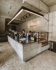 two people standing at a counter in a restaurant