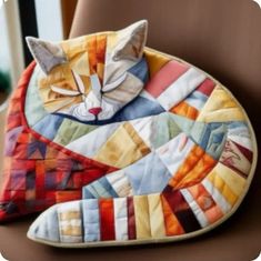 a cat shaped pillow sitting on top of a chair