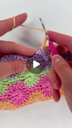 someone is crocheting the stitchs together to make a colorful piece of yarn