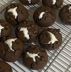 chocolate cookies with white frosting sitting on a cooling rack