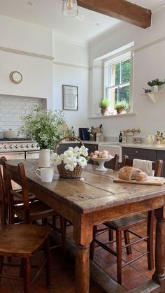 a wooden table sitting in the middle of a kitchen