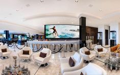 a living room filled with lots of furniture and a flat screen tv mounted to the wall