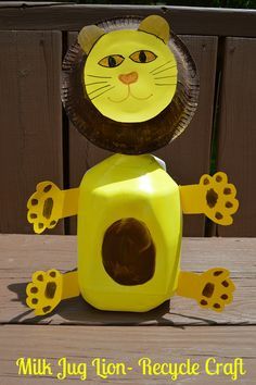 a paper plate lion sitting on top of a yellow container