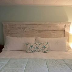 a bed with white linens and blue pillows