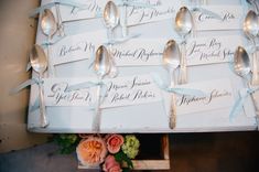 there are forks and spoons on the table with name tags attached to each fork