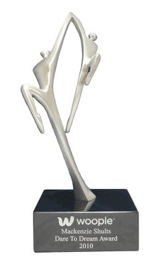 a silver trophy with two people holding hands in the shape of a heart on it