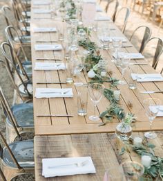 a long wooden table with place settings on it