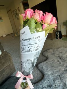 a bouquet of pink roses wrapped in newspaper