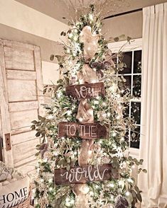 a christmas tree decorated with wooden signs and lights