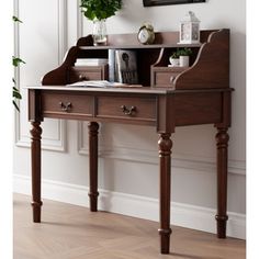 a wooden desk with books and plants on it