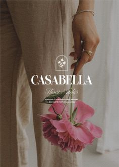 a person holding a pink flower in their hand with the words castebella on it