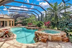 an outdoor swimming pool surrounded by palm trees and other greenery, with a gazebo in the background