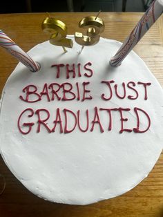 a cake with writing on it that says, this barbie just graduated and two baseball bats