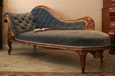 an old fashioned chaise lounge with a book on it