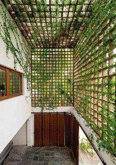 an open room with lots of green plants growing on the walls and ceiling, along with a tiled floor