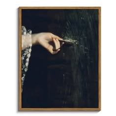 a woman's hand reaching for something in the dark, with water droplets on it