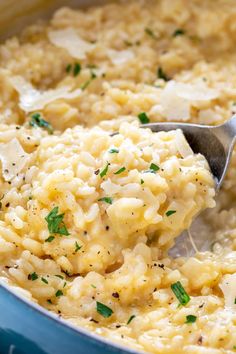 a spoon full of rice and parsley in a blue pot