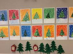 christmas cards are displayed on the wall with paper trees and small houses in front of them