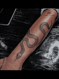 a man's arm with a snake tattoo on it