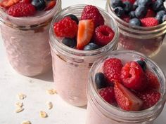 three jars filled with fruit and oatmeal on top of a table