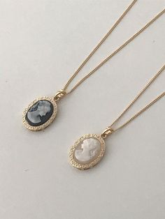 This elegant long necklace features a signature European cameo lady pendant motif, available in both cream and black colorways with premium brass and 14k gold electroplating. The versatile 60cm chain with 5cm extension perfectly complements the moderately sized 2cm pendant, striking an ideal balance between statement and subtlety. The vintage-inspired design effortlessly elevates any outfit while maintaining a timeless, antique-mood aesthetic that makes it a sophisticated addition to any jewelry collection.Color: Cream Cameo, Black Cameo Vintage Statement Necklace, Lady Cameo Necklace, Cameo Necklace Outfit, Runners Outfit, Vintage Opulence, Black Cameo, Mood Aesthetic, Necklace Outfit, Oval Necklace