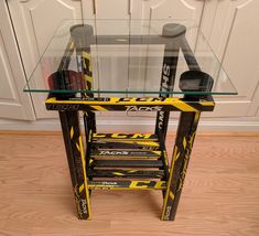 a glass table with yellow and black items on it in front of a white door